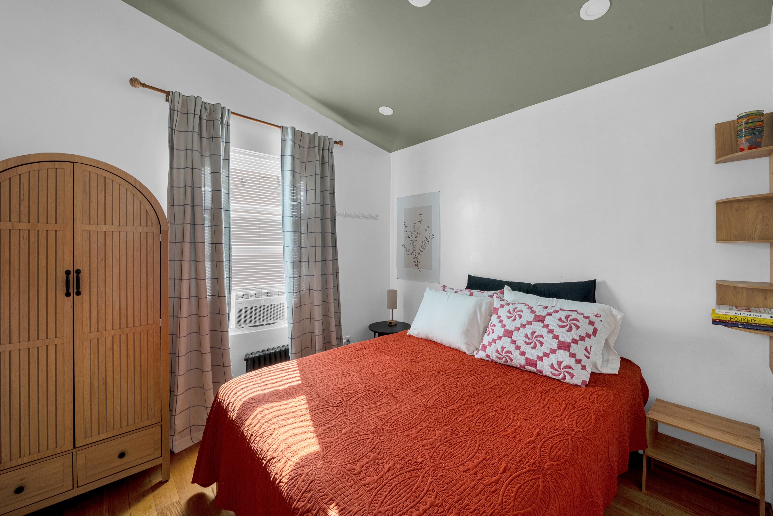 The Beach House — bedroom with queen bed and warm textiles